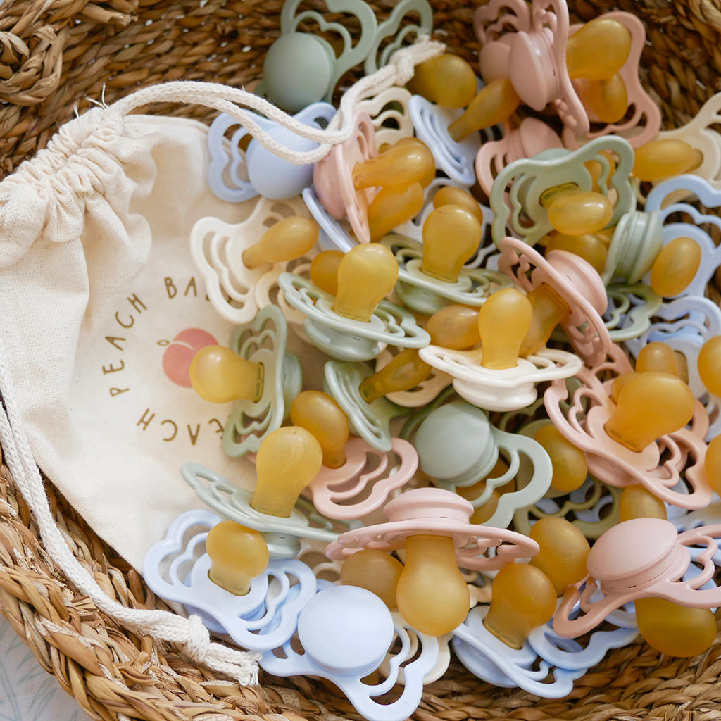 BIBS Supreme baby dummies in pastel shades in rattan basket